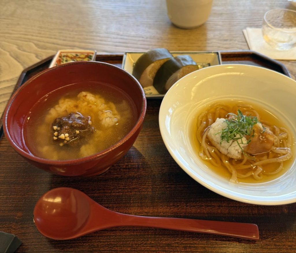 赤い丼に入ったスープとご飯、白い皿に盛られた麺料理。